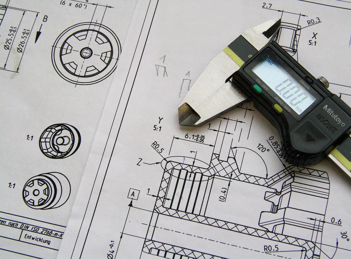 Engineering blueprints with precision measurement tools showcasing technical design and manufacturing expertise